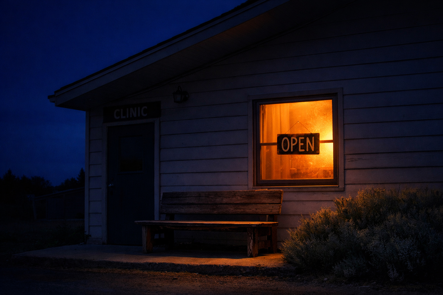 Rural clinic exterior at dusk with one lit window, an empty bench at the entry, and an Open sign glowing inside.